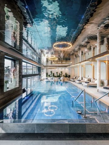 Innenpool mit modernen Liegen und Wasserreflexionen