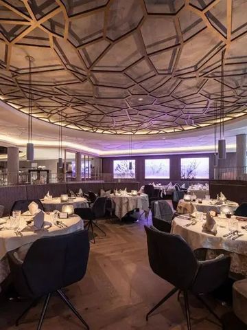 Restaurant mit stilvoller Decke und gedeckten Tischen