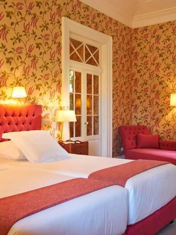 Elegantes Schlafzimmer mit floraler Tapete und rosa Akzenten.