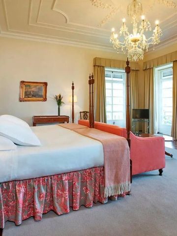 Geräumiges Hotelzimmer mit Himmelbett und luxuriösem Ambiente.