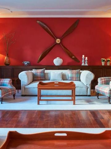 Elegante Lounge mit roten Wänden und stilvollen Sesseln