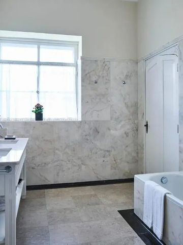 Luxuriöses Badezimmer mit Marmordekor und großer Badewanne