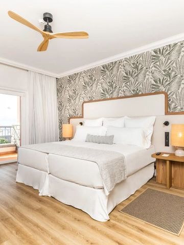 Geräumiges Hotelzimmer mit Balkon und stilvollen Holzakzenten