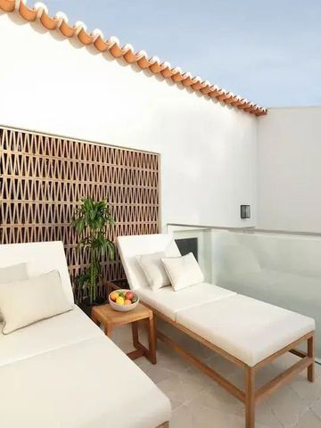 Private Terrasse mit zwei Liegen und Blick auf den klaren Himmel.