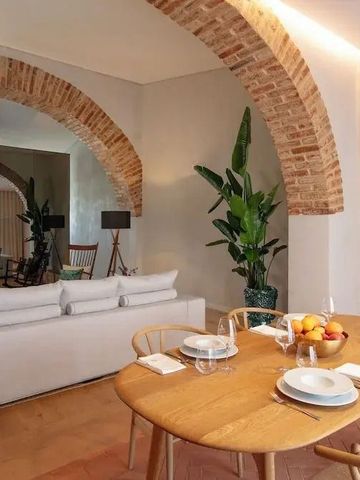 Essbereich in einer Suite mit rustikalen Ziegelbögen und stilvoll gedecktem Tisch.