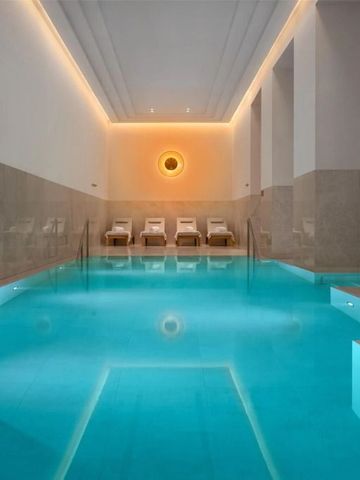 Innenpool mit entspannenden Liegen und stimmungsvoller Beleuchtung.