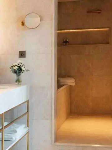 Luxuriöses Badezimmer mit Marmoroberflächen, modernen Armaturen und dekorativen Elementen.