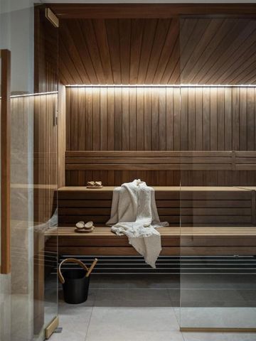 Gemütliche Sauna mit Holzwänden, Sitzbänken und dezenter Beleuchtung.