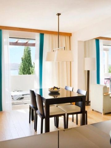 Helle Suite mit Esstisch und Meerblick durch große Fenster