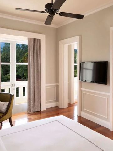 Helles Hotelzimmer mit Balkon und eleganter klassischer Einrichtung