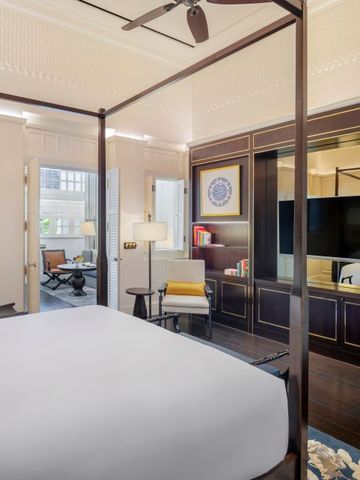 Luxuriöses Zimmer im Raffles Singapore mit Himmelbett und modernem Interieur.