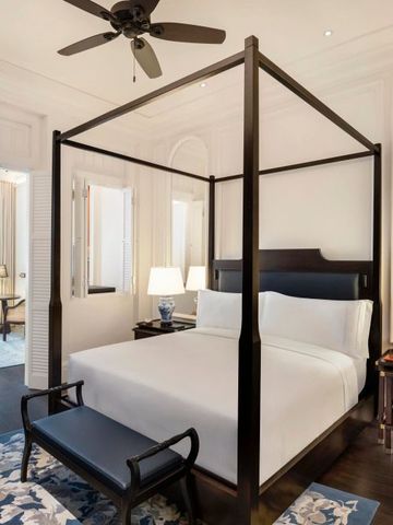 Geräumige Suite im Raffles Singapore mit edler Einrichtung und Himmelbett.