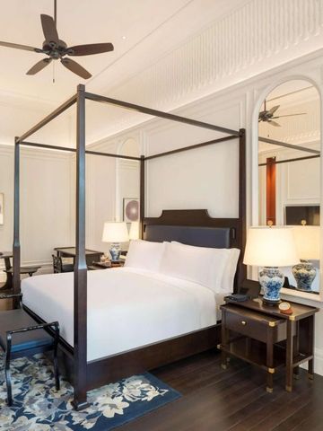 Großzügiges Schlafzimmer im Raffles Singapore mit luxuriöser Ausstattung.