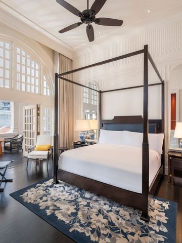 Luxuriöses Schlafzimmer mit einem großen Himmelbett, eleganten Möbeln und großen Fenstern.