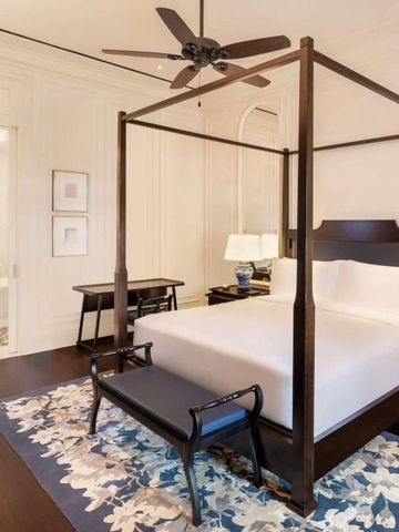 Elegantes Schlafzimmer mit Himmelbett, einem Schreibtisch und sanfter Beleuchtung.