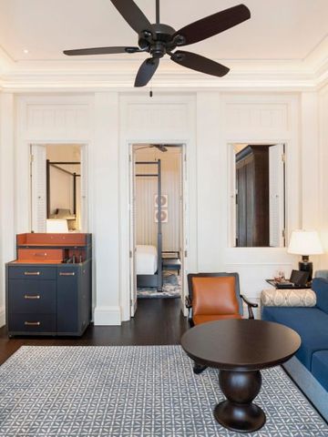 Großer eleganter Wohnbereich mit Sofa, Sesseln und edlem Tisch.