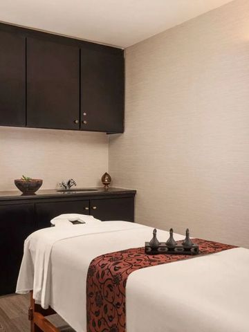 Ruhiger Behandlungsraum im Spa mit Massageliege und dezenter Dekoration.