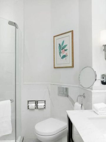 Helles Badezimmer mit modernem Waschbecken und Glasdusche