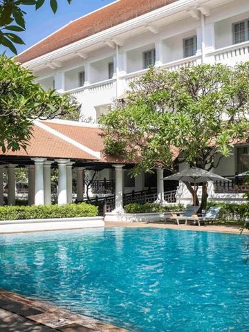 Schöner Pool umgeben von Bäumen und einem weißen Gebäude