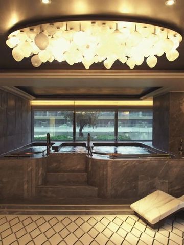 Luxuriöser Spa-Bereich mit großem Fenster und stilvollem Kronleuchter.