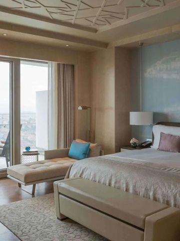 Elegantes Zimmer mit Blick auf den Balkon und die Stadt.