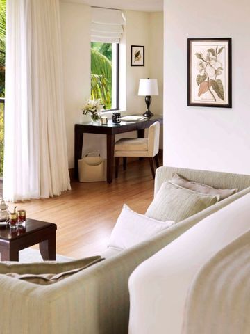 Geräumiges Zimmer mit Schreibtisch und Balkon im Raffles Seychelles