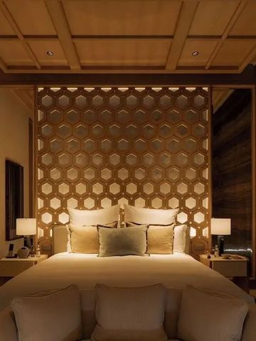 Luxuriöses Hotelzimmer mit dekorativer Trennwand und stimmungsvoller Beleuchtung