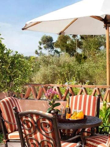 Terrasse mit Sitzgruppe und Sonnenschirm in grüner Umgebung