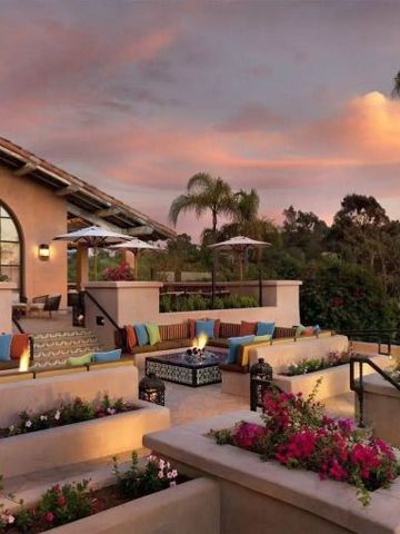 Terrasse mit farbenfrohen Kissen und Blumen im Rancho Valencia Resort.