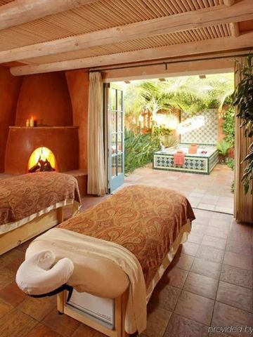 Massageraum mit zwei Liegen und Blick auf Garten im Rancho Valencia Spa.