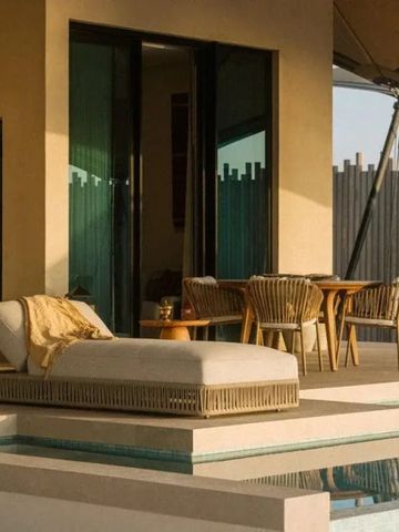 Terrasse mit Liegestuhl und Esstisch am Pool bei Our Habitas Ras Abrouq