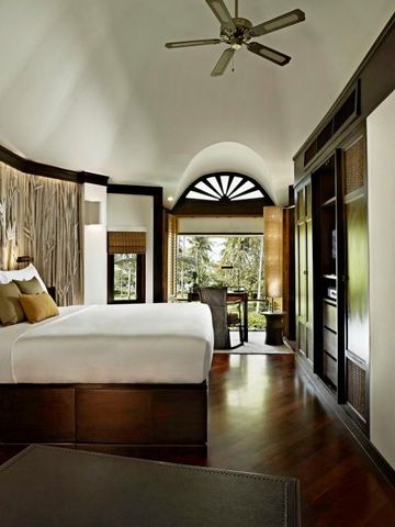 Luxuriöses Schlafzimmer im Rayavadee Hotel mit stilvollen Holzakzenten und modernem Design.