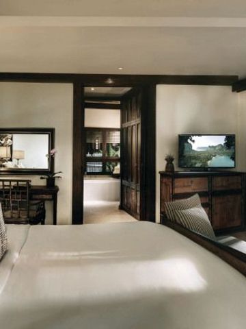 Komfortabel eingerichtetes Zimmer mit edlem Holzmobiliar im Rayavadee Hotel.