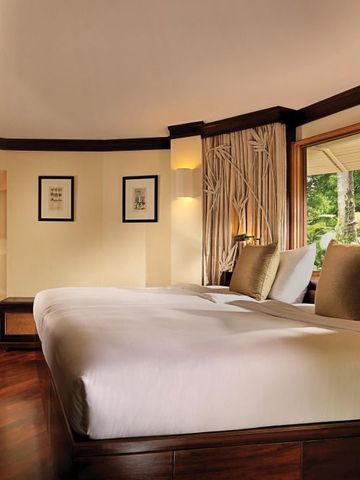 Geräumiges Hotelzimmer mit Blick auf tropische Natur im Rayavadee Hotel.