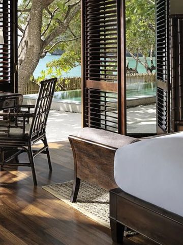 Helles Zimmer mit Holzfußboden und Blick auf Garten und Pool