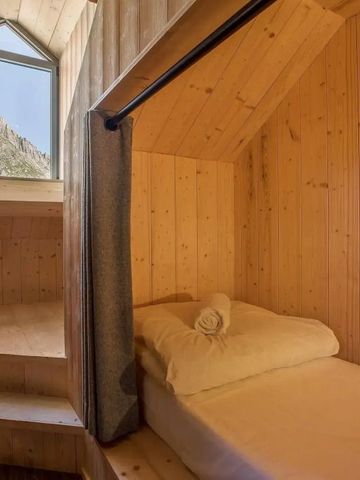 Holzvertäfeltes Dachzimmer mit Einzelbett und Bergblick