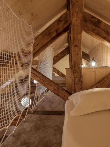 Gemütliches Zimmer aus Holz mit Dachbalken und weißem Netz.