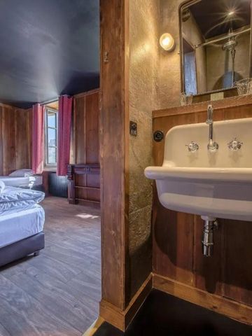 Zimmer mit hölzerner Einrichtung und separatem Waschbeckenbereich.