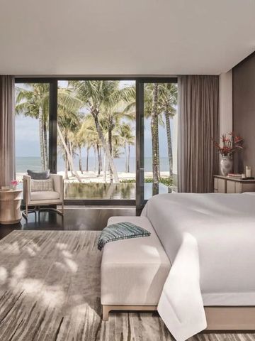 Zimmer mit Meerblick durch große Fenster und stilvolle Einrichtung.