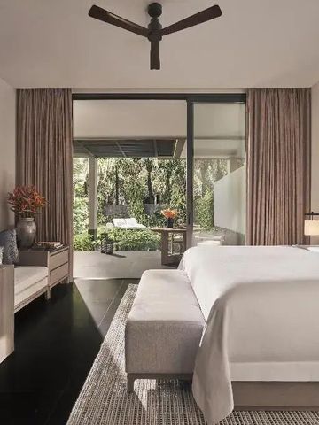 Luxuriöse Suite mit großem Bett und Terrasse mit Gartenblick