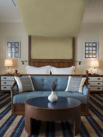 Geräumiges Doppelzimmer in neutralen Tönen mit modernem Dekor und Sitzecke.