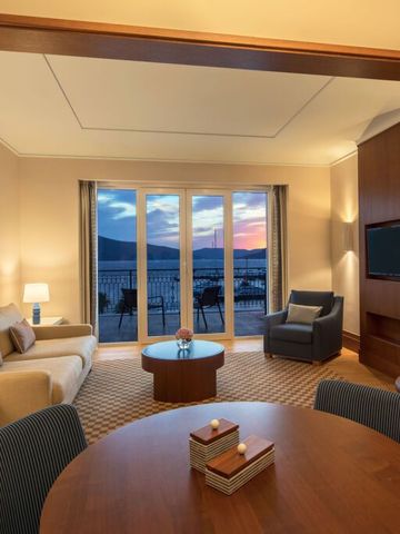 Geräumige Suite mit Meerblick und gemütlicher Sitzgruppe im Regent Porto Montenegro.