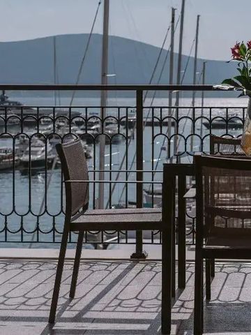 Terrasse mit Blick auf die Hafenanlage und Berge im Hintergrund
