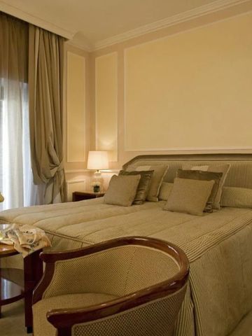 Gemütliches Hotelzimmer mit Doppelbett und sanften Erdtönen