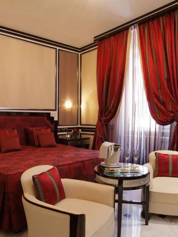 Luxuriöses Schlafzimmer mit roter Bettwäsche und eleganten Vorhängen