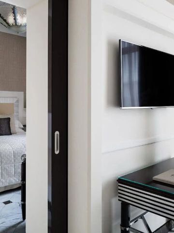 Moderner Schlafbereich mit Flachbild-TV und klaren Linien