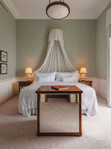 Elegant eingerichtetes Schlafzimmer mit Himmelbett und Balkon