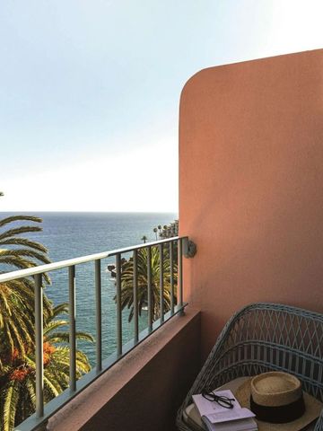 Balkon mit Meerblick und Palmen am Horizont