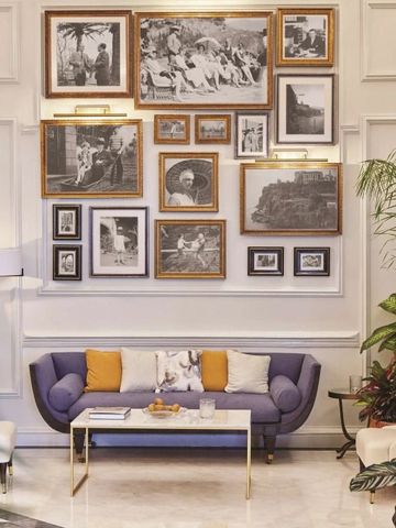 Elegante Lounge mit blauen Sofas und dekorativen Bildern an der Wand