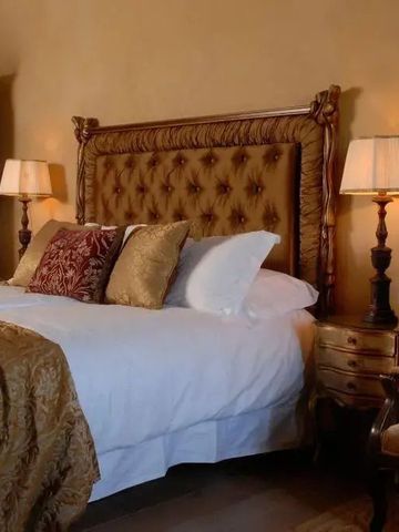 Klassisches Zimmer mit gepolstertem Bett und warmem Ambiente im Borgo Santo Pietro